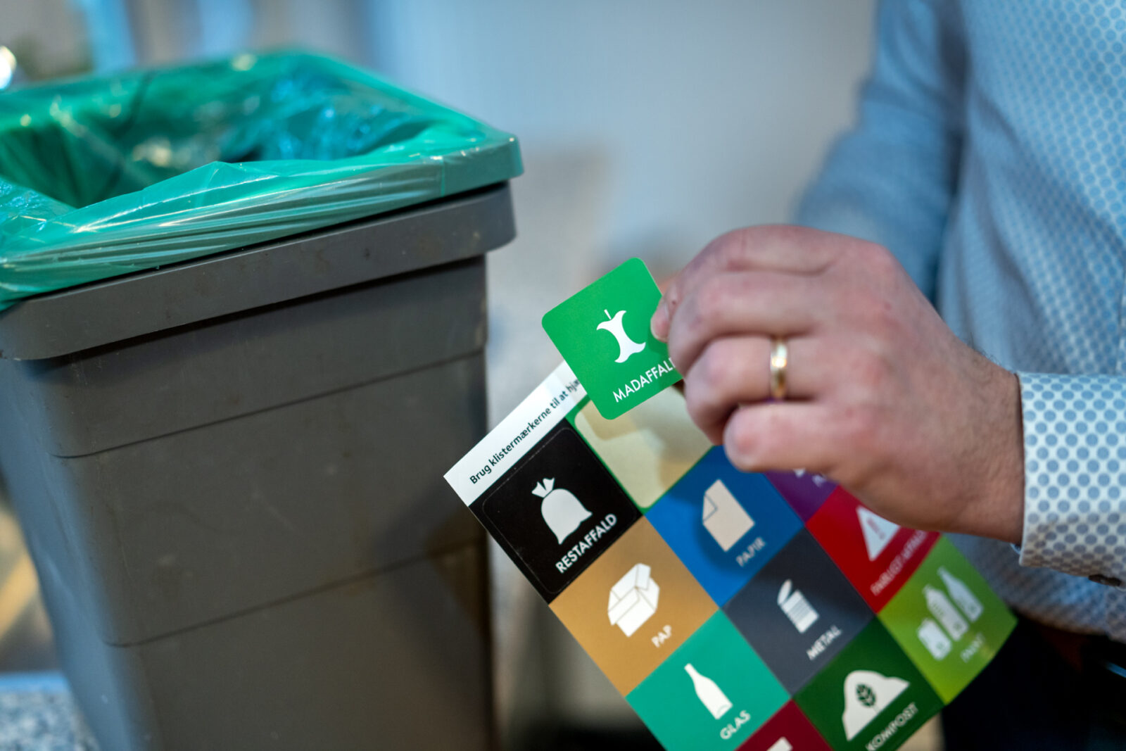Billedet viser et ark med klistermærker til indendørs affaldssortering.