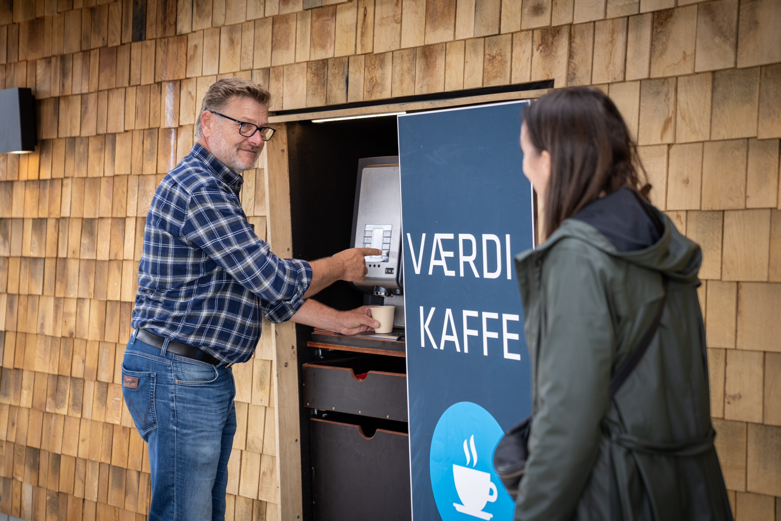 Kunde trækker en gratis kop kaffe i automaten på genbrugspladsen. Her i Værdipark Ry.